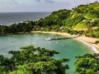 Small green island bay with boats