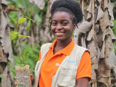 Woman holding a plant in a forest